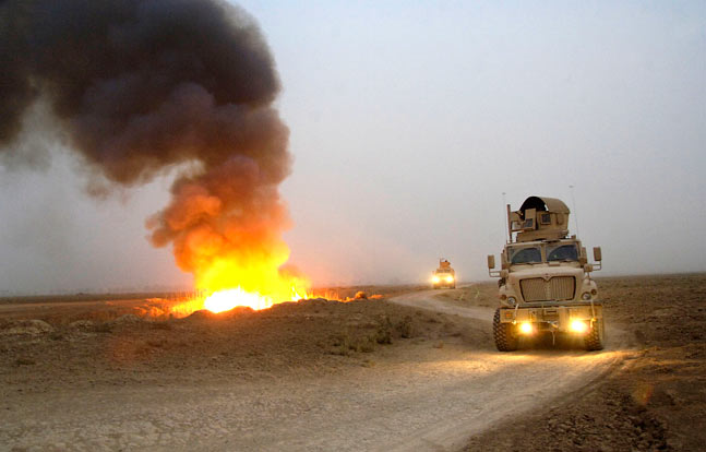 A blast near a convoy shows the devastating potential of IEDs in the field. Increasingly, the U.S. armed forces have used up-armored trucks and MRAP vehicles for what used to be routine transport missions.