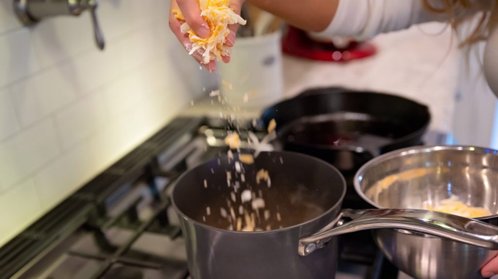 Once the beer and garlic have come to a boil, add the flour covered cheese to the pot.