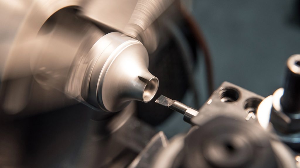 A baffle is turned on a lathe before being welded into a custom baffle stack.