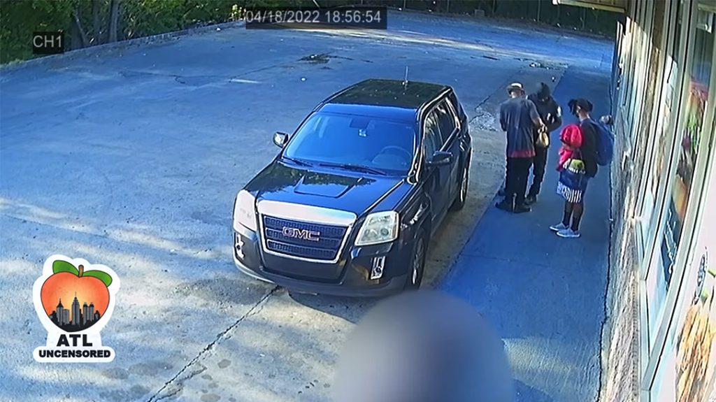 Passersby look over loot from a recently shot Atlanta security guard.