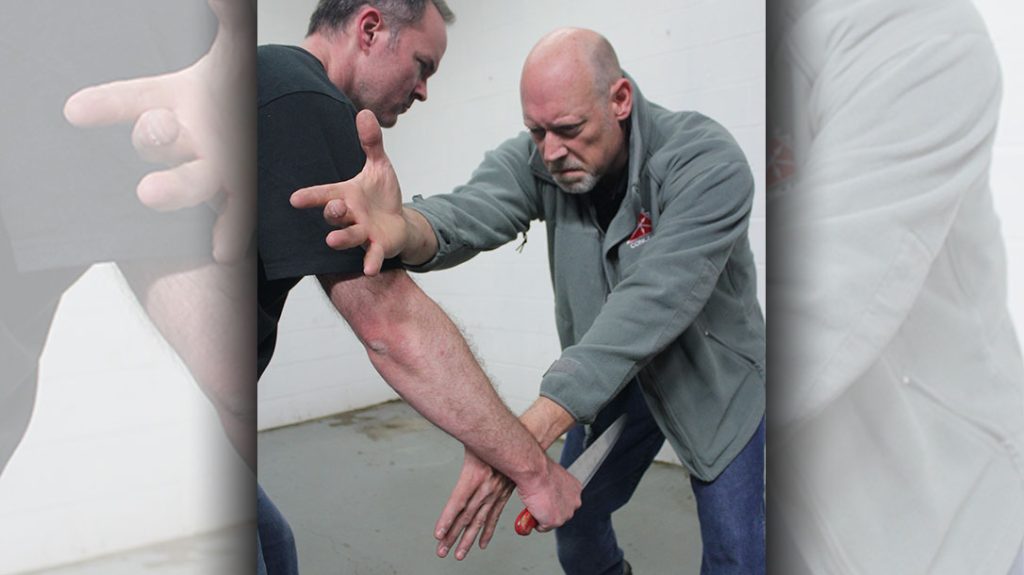 The first rule of drawing a pistol at close range is stay alive long enough to do it. That means protect yourself first, then draw.