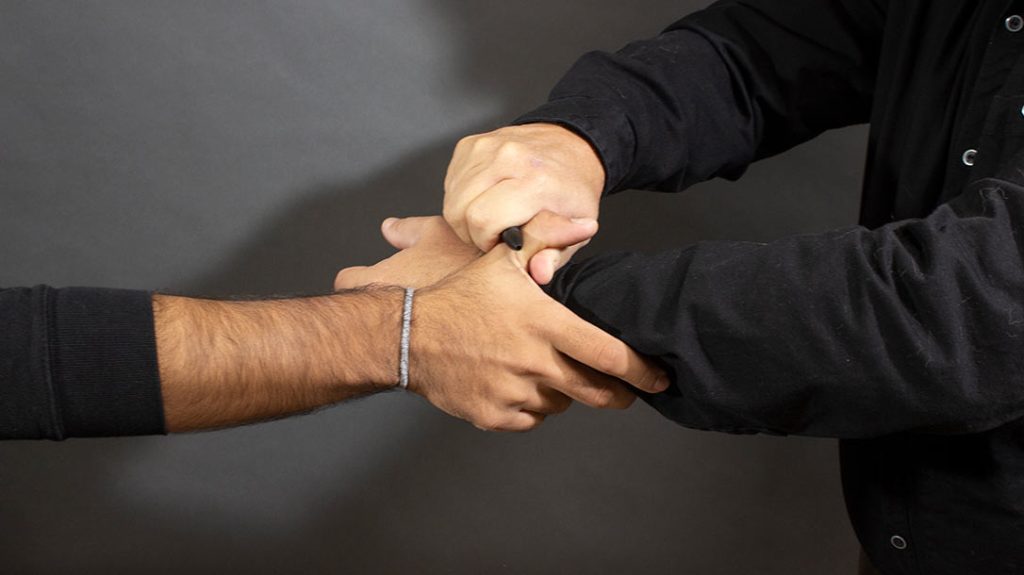 If you can get ahold of it with your pen, pressure to the thumb is also a great self-defense technique.