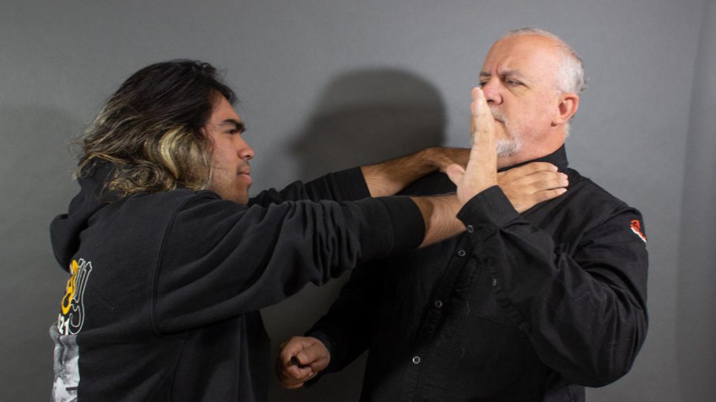 The attacker applies a two-handed front choke.