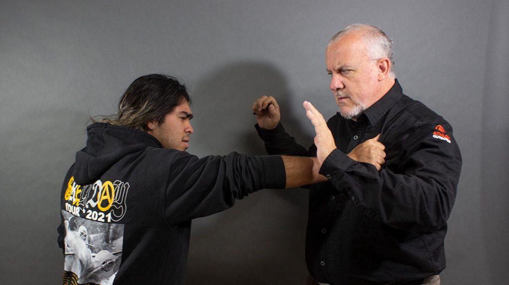 The attacker grabs your lapel, preparing to strike.