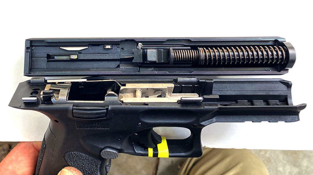 The dismounted slide oriented next to the frame as if it was in battery showing the curiously minimal engagement between the slide and the frame’s four guide rails.