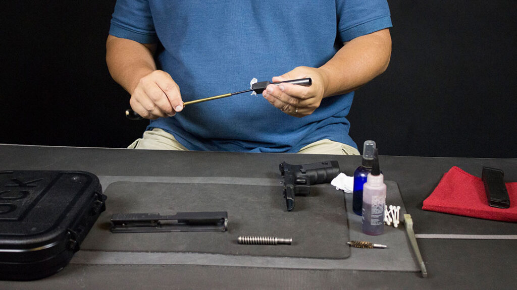 Cleaning a pistol: Clean the barrel.