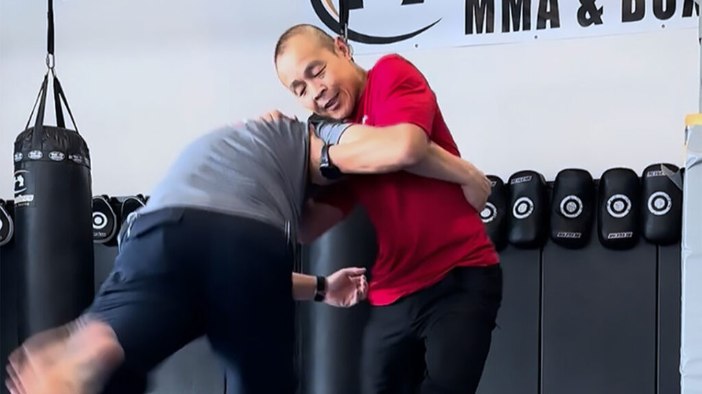 Dr. Conrad Bui (right) demonstrates one way to defend against a takedown attempt by an attacker.