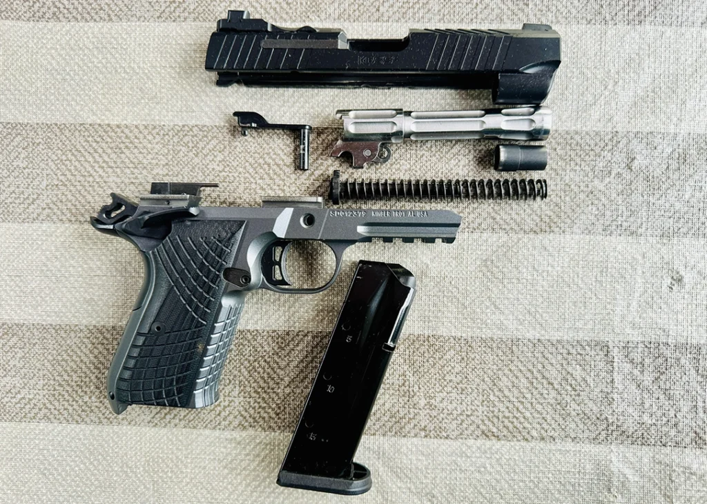 Disassembly for the Kimber KDS9c Rail is similar to most 1911 platform pistols; note the fluted stainless-steel barrel, and flat-coil recoil spring, with guide rod.