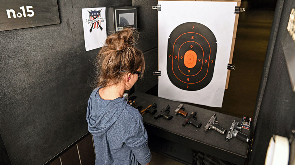 The author steadies herself before shooting a 9mm handgun for the first time.