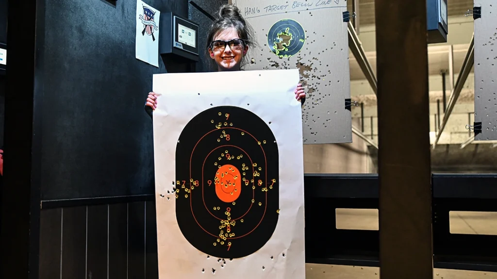 The author holds up her target after her first time shooting at an indoor gun range.