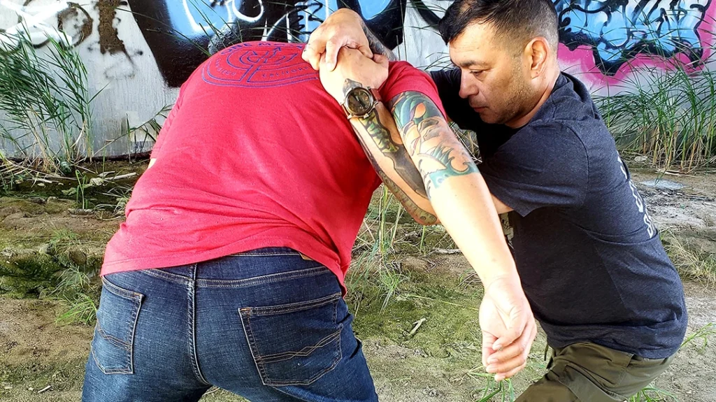 Clinching his hands together, Johnny drops his full weight on the back of Sam’s rotator cuff.