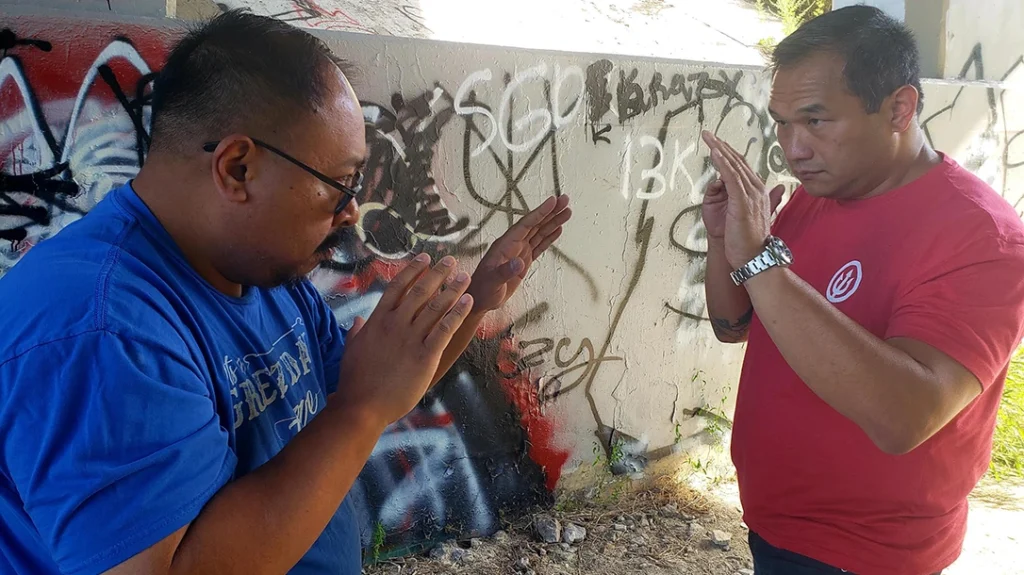 Frank, the would-be-attacker, squares off against a Sam. Both men have a passive open-hand guard up.
