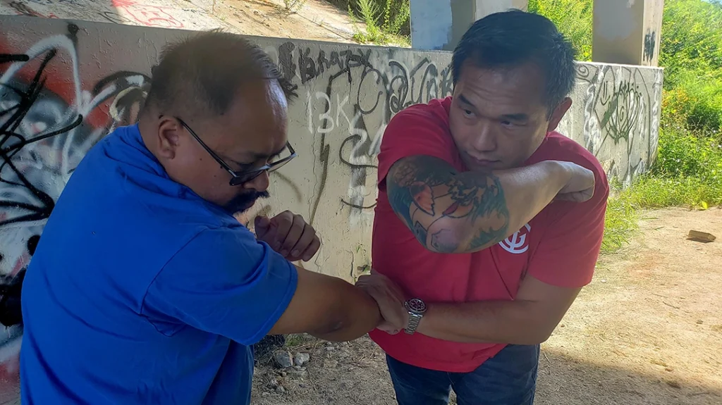 Basic Knee and Elbow Strikes: Sam’s elbow strike cuts through and across Frank’s head.