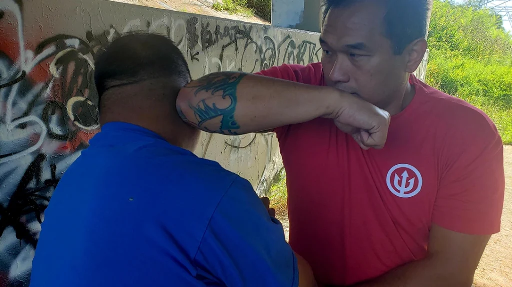 Sam drives his elbow back into the opposite side of Frank’s head.