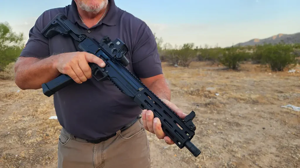 The gun uses a Uzi-style overhung bolt housed in an aluminum receiver.