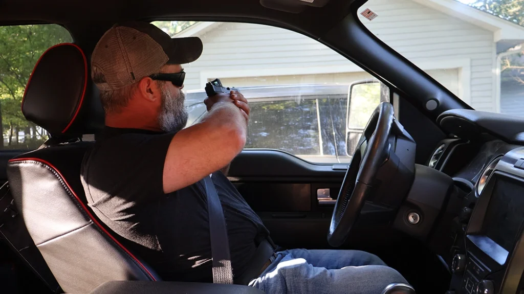 When shooting through the near window, compress the pistol to avoid contact with the window.