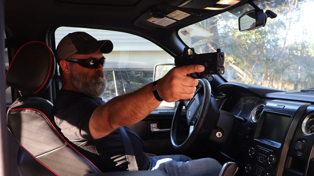Vehicle Pistol Combat: When the threat is at the far window, one-handed shooting is usually the most expedient method.