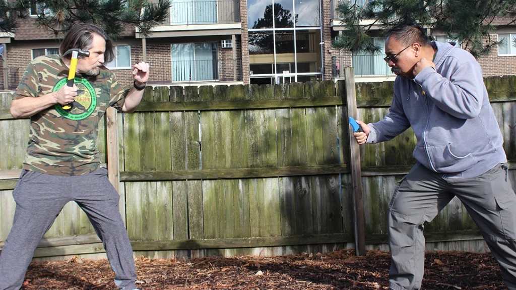 Don and Frank are squared off, ready to fight. Frank has a knife, and Don has a work hammer that he keeps in his car.