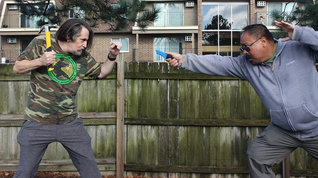 Frank lunges at Don with his knife.