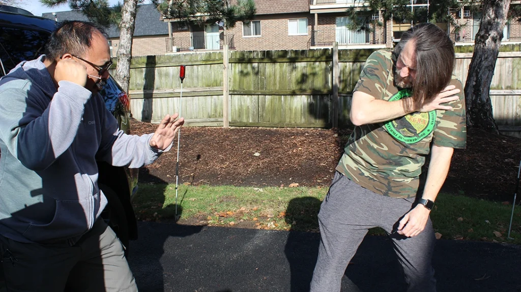 Improvised Vehicle Weapons: Don takes a step back, holding his chest, and Frank raises his guard to defend.