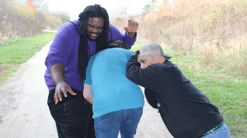 Then the author spins and forcefully drives/thrusts attacker number one into attacker number two, effectively slowing down multiple attackers at once.