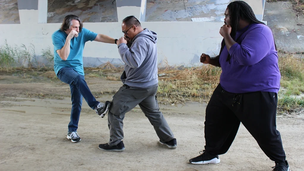 When the closest attacker steps into Don’s kicking range, Don stomp-kicks him right on his kneecap so he can focus on the other multiple attackers (if there are more).