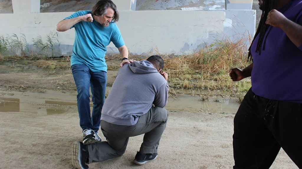 When the attacker drops, Don immediately follows up with an ankle stomp. The goal is to break the attacker’s ankle, disabling his ability to stand or fight.