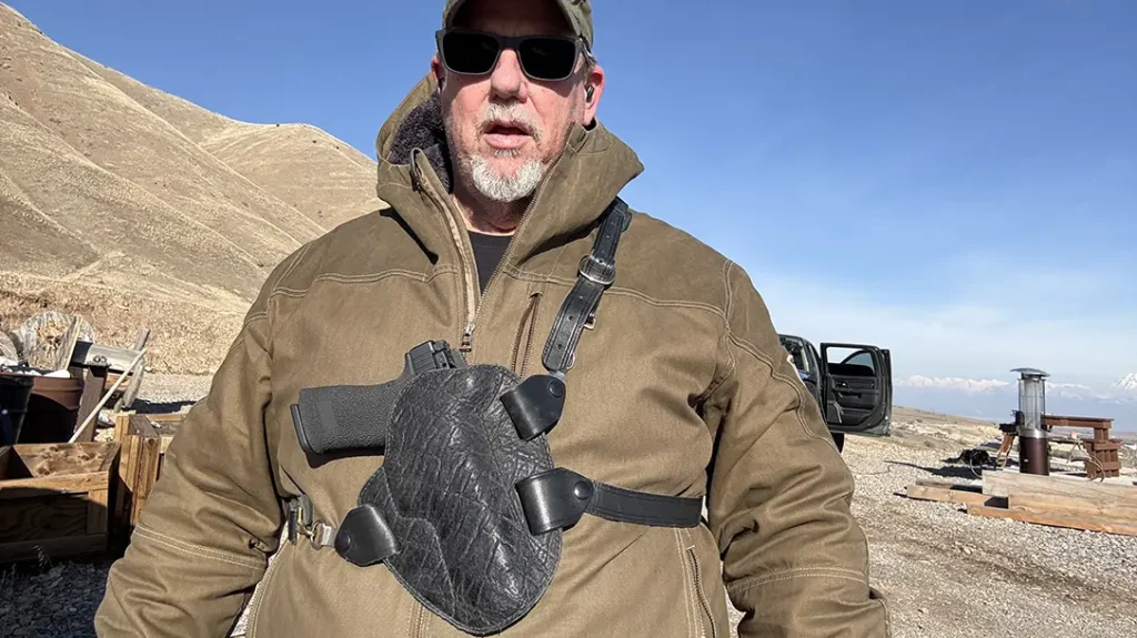 The author carries his revolver with a red dot installed in a chest rig when in the backwoods.