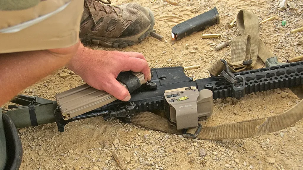 Grab the magazine you ripped out of the weapon, hook the charging handle, and run it as far back as it will go.