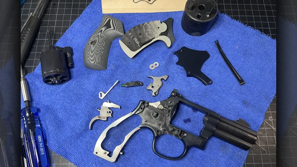 The fully disassembled Smith & Wesson revolver for maintenance.