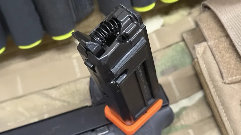 The dry fire magazine uses a spring-tensioned lever to simulate the trigger pull.