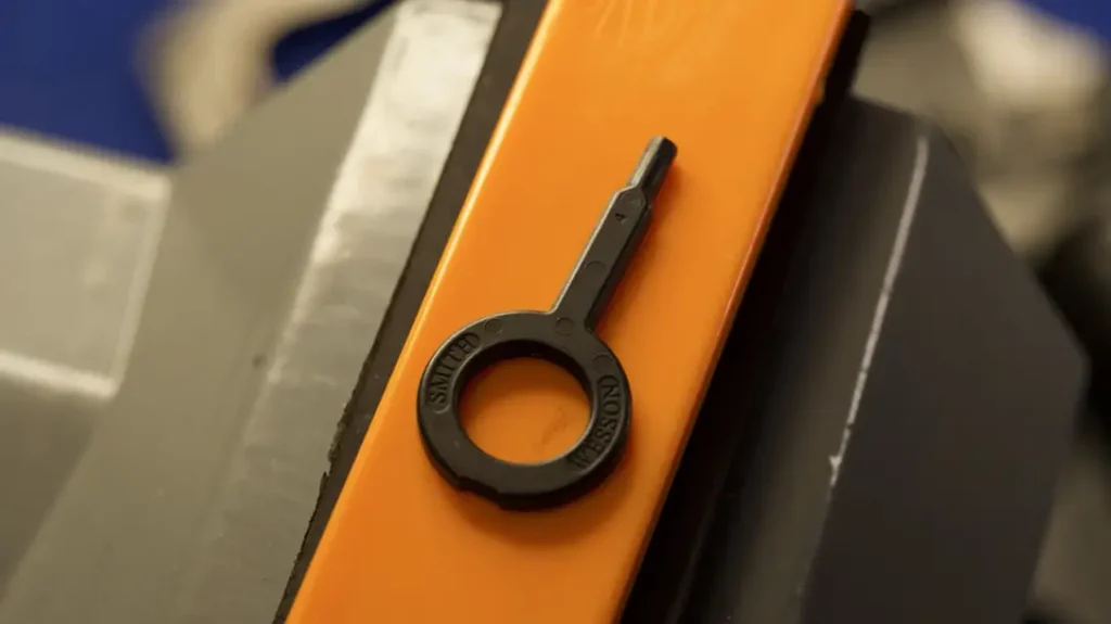 Insert a small key into the left side of the frame just above the cylinder release latch, give it a turn, and a cam rotates internally.