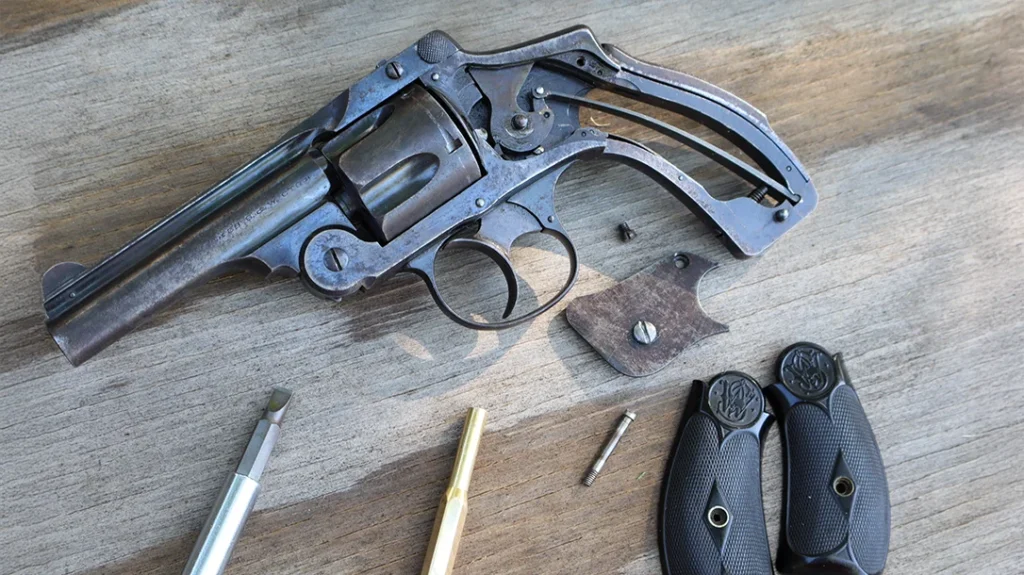 The first step in disassembling the Smith & Wesson New Departure is to remove the grips followed by a small set screw in the side plate.