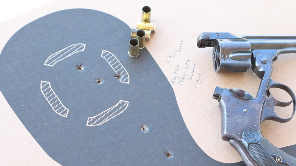 The front sight consists of a pinned front half-moon and a narrow rear notch forward of the frame latch.