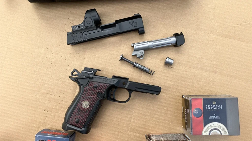 The 1911 field stripped. Fluted barrel and chamber, and dual-spring recoil spring are evident.