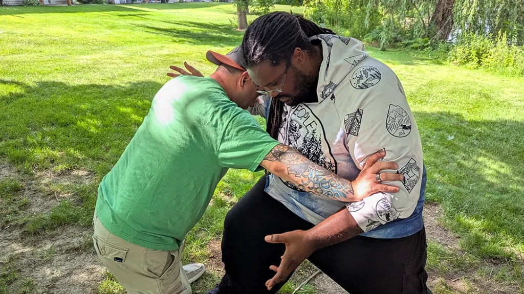 The Author steps in with an outside middle block, stopping Kysean's right-handed punch. Simultaneously driving the support hand to grab and control Kysean’s left forearm, driving it back to prevent a follow-up strike.