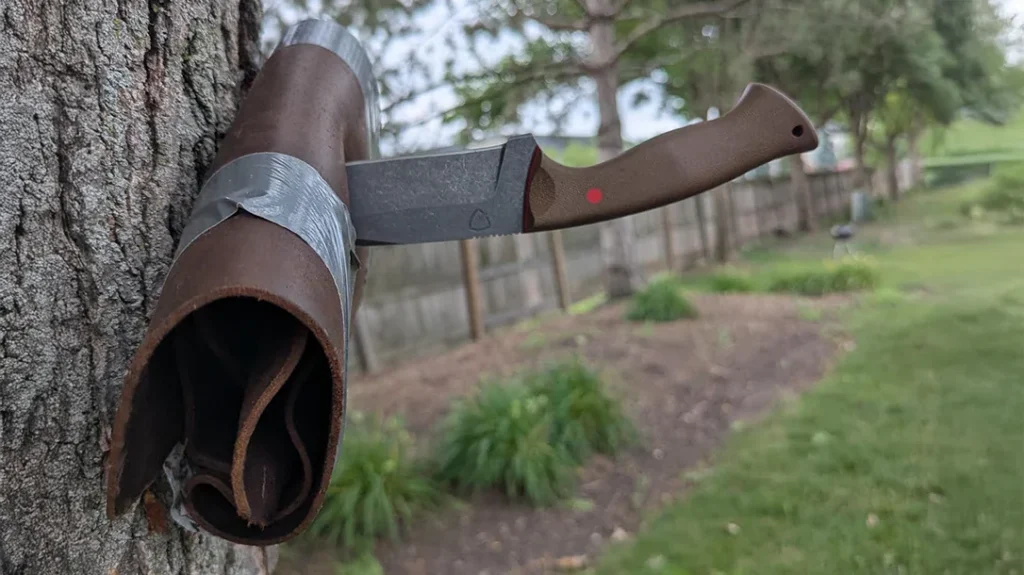 The author stabbed through the leather roll and into a tree with the Osprey Ferox Combat Bowie.